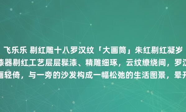 飞乐乐 剔红雕十八罗汉纹「大画筒」朱红剔红凝岁月，层叠雕纹藏禅意。以漆器剔红工艺层层髹漆、精雕细琢，云纹缭绕间，罗汉群像栩栩如生，卷画轻倚，与一旁的沙发构成一幅松弛的生活图景，晕开一抹沉静古意，是文房雅器。26*26*35.6cm#全国春日美景图鉴# #画筒#